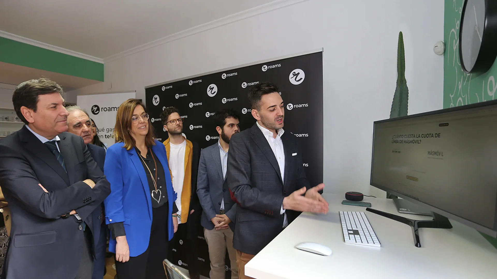 Eduardo Delgado muestra una web en un monitor a un grupo de autoridades durante una visita a las oficinas de Roams.