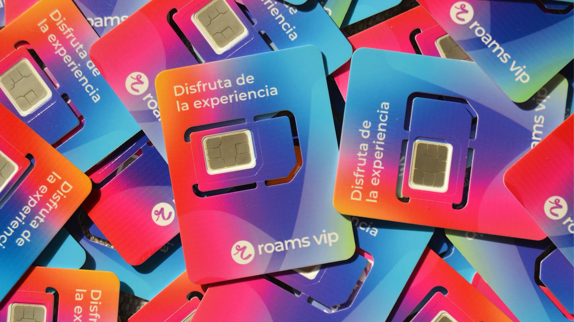 Tarjetas SIM de colores de Roams amontonadas, con el lema "Disfruta de la experiencia".