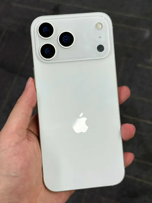 Mano sosteniendo un prototipo de iPhone 17 Pro en color blanco con un nuevo diseño de triple cámara en la parte trasera.