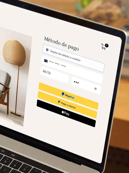 Pantalla de portátil con formulario de pago online mostrando tarjeta bancaria, PayPal y Apple Pay.