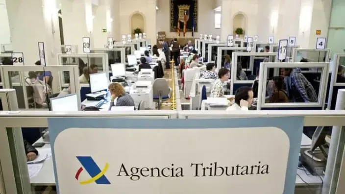 Oficina de atención al público de la Agencia Tributaria con funcionarios trabajando en sus puestos para gestiones de IRPF.