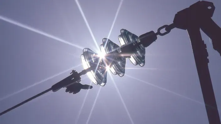 Aisladores eléctricos de vidrio con destellos de sol en línea de transmisión
