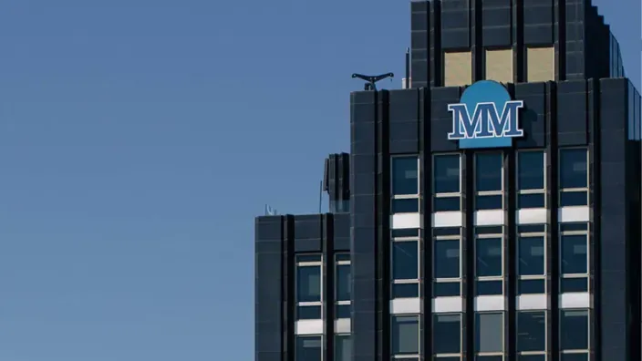 Fachada superior de un edificio con el logotipo de Mutua Madrileña sobre fondo azul