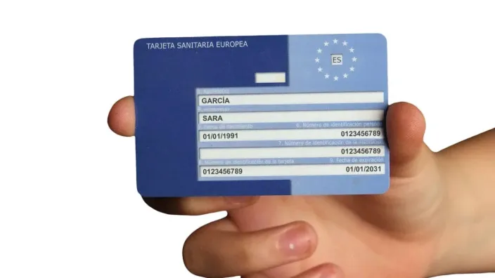 Mano sosteniendo la Tarjeta Sanitaria Europea (TSE), necesaria para recibir asistencia médica al viajar por Europa.