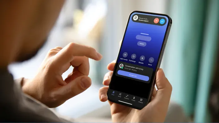 Usuario utilizando la aplicación móvil de Revolut para gestionar finanzas personales