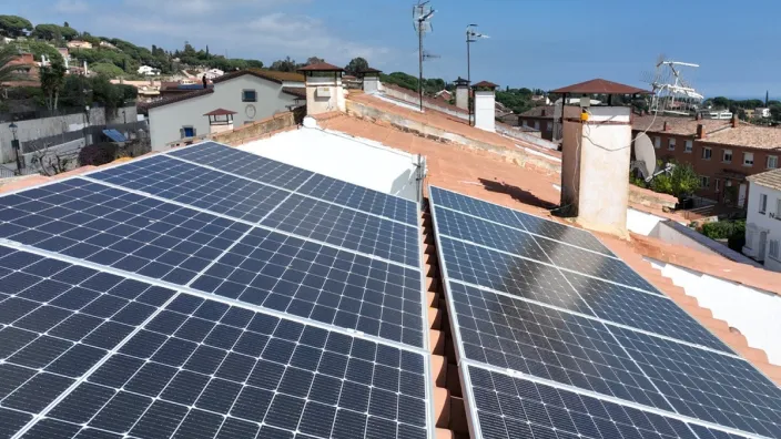 Paneles solares instalados en el tejado de una vivienda en un barrio residencial.