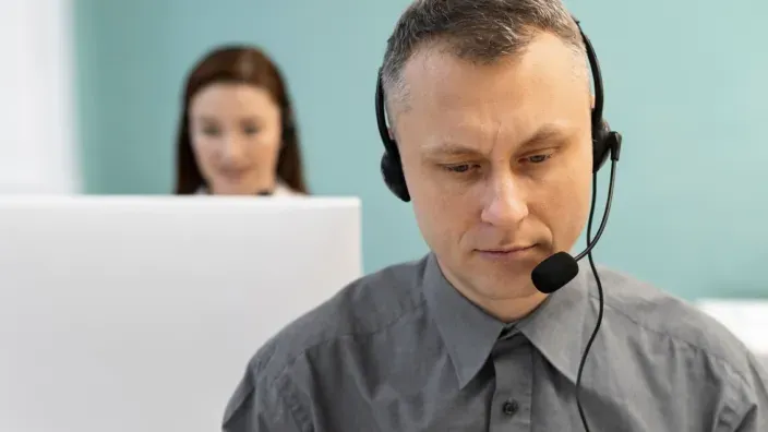 Agente de atención al cliente con auriculares trabajando en soporte técnico o call center.