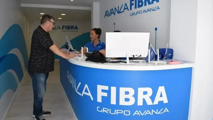 Cliente consultando con una asesora en una oficina de Avanza Fibra para contratar servicios de internet y telefonía.