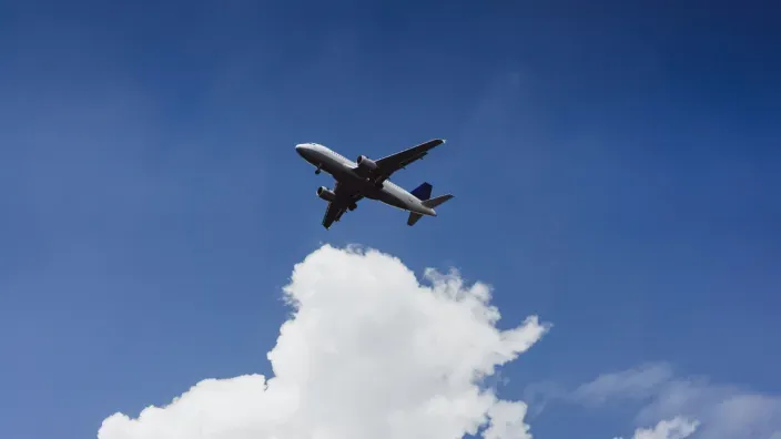 Avión volando en el cielo sobre una nube blanca