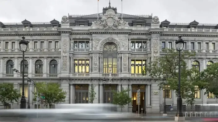 Fachada principal del edificio del Banco de España en Madrid con tráfico difuminado en primer plano.