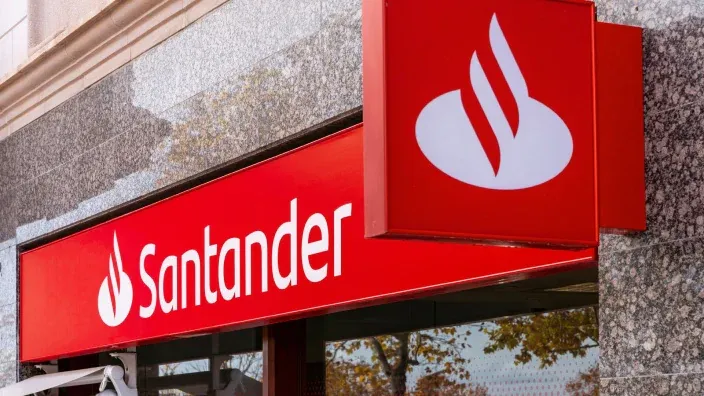 Cartel exterior de una oficina del Banco Santander con su logotipo rojo en la fachada.