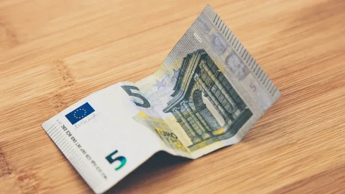 Billete de 5 euros sobre una mesa de madera
