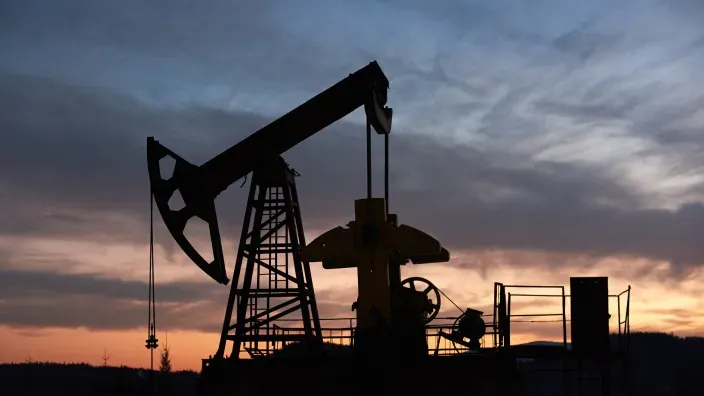 Bomba extractora de petróleo en funcionamiento al atardecer