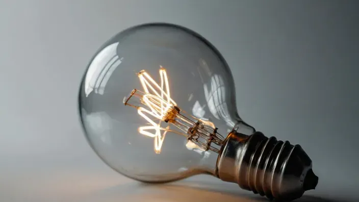 Bombilla incandescente encendida sobre fondo neutro en primer plano