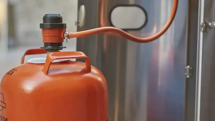 Bombona de gas butano conectada a una instalación industrial de energía