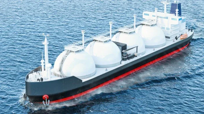 Buque metanero transportando gas natural licuado (GNL) navegando en el mar.