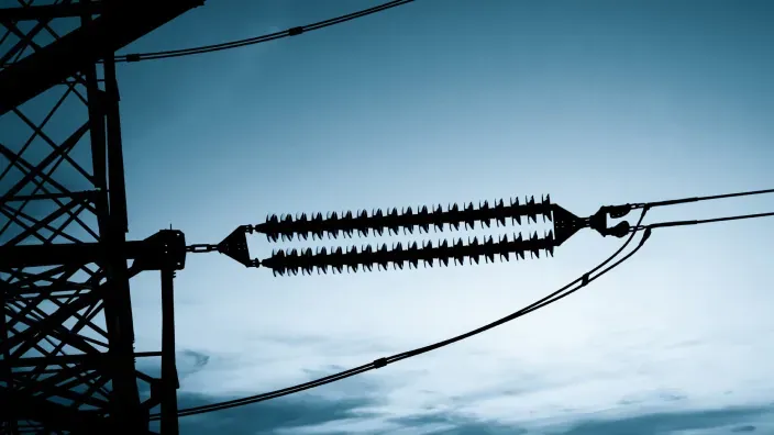 Cables eléctricos de alta tensión al atardecer.
