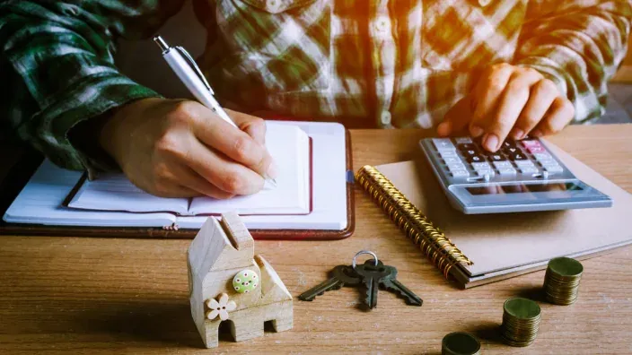 Persona calculando la financiación de una hipoteca para la compra de una casa.