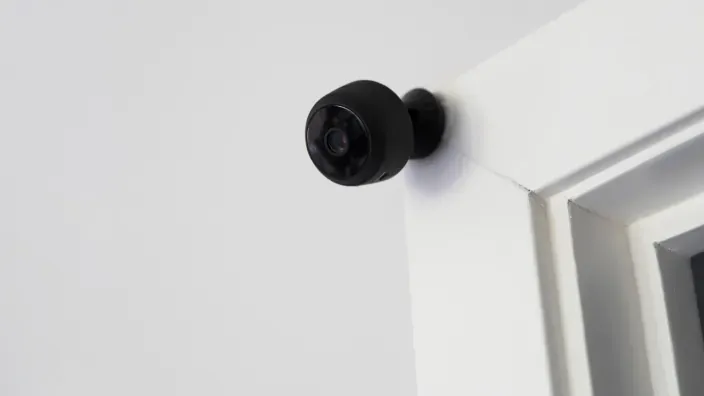 Cámara de seguridad instalada en la esquina superior de una puerta interior.