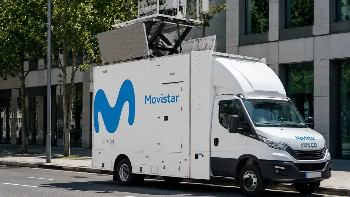 Camión técnico de Movistar con una antena elevada aparcado en una calle