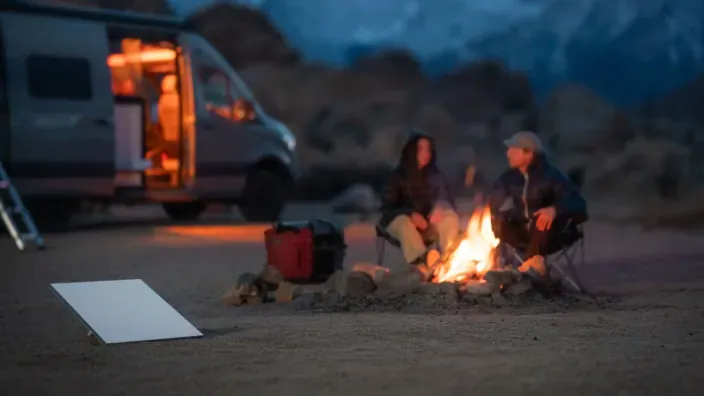 Antena Starlink para camping con furgoneta y hoguera, ofreciendo internet satelital en plena naturaleza.
