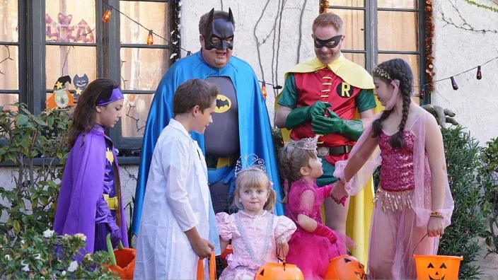Personajes de Modern Family disfrazadas de superhéroes y princesas celebrando Halloween al aire libre