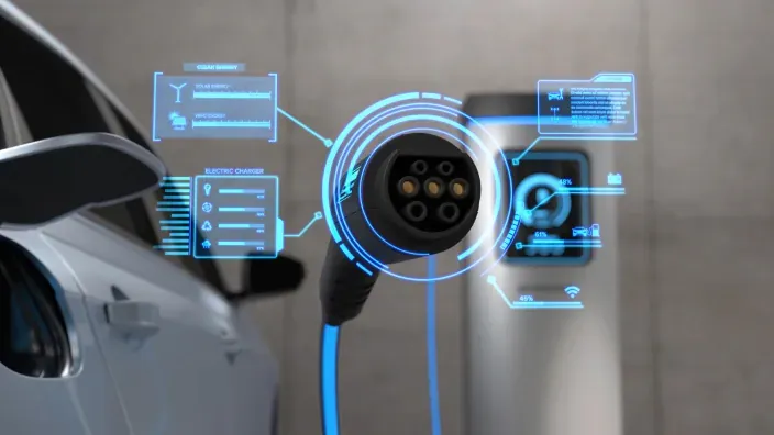 Detalle de conector de carga para coche eléctrico con interfaz holográfica de datos de energía.