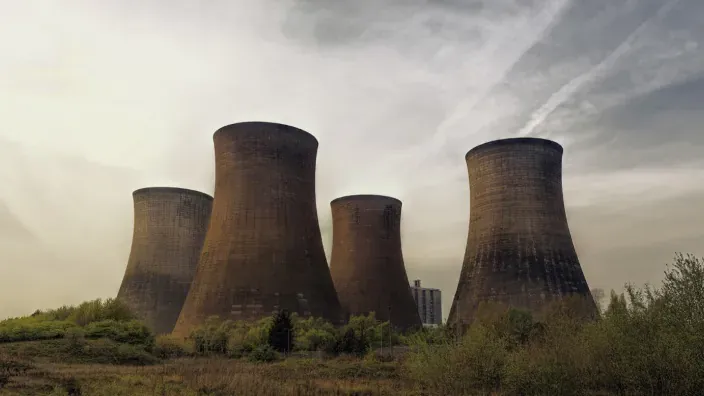 Central de energía nuclear en funcionamiento con cuatro chimeneas.