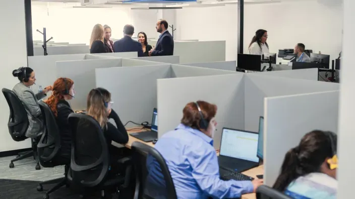 Oficina de un call center con teleoperadores trabajando.