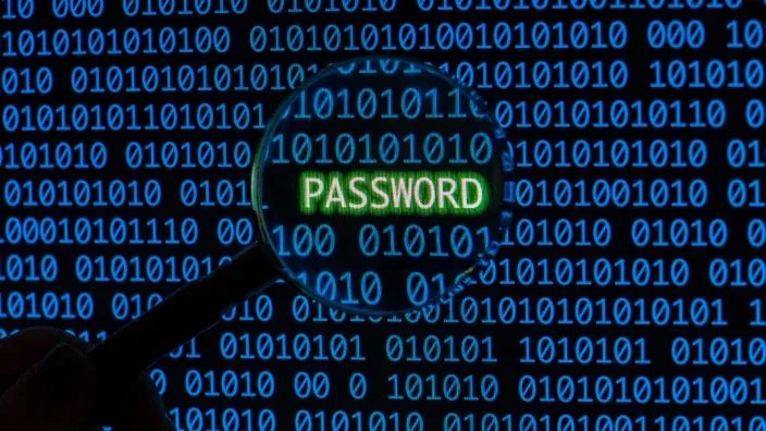 Lupa analizando la palabra Password sobre código binario, representando la seguridad de datos y ciberseguridad.