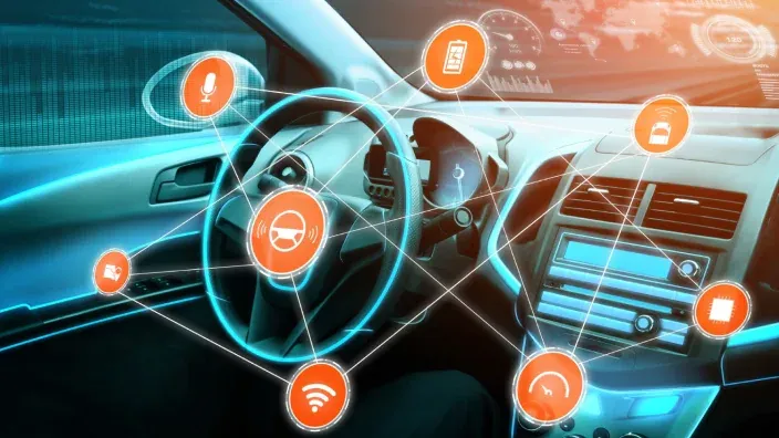 Interior de un coche conectado con iconos digitales de tecnología inteligente e internet de las cosas para vehículos.