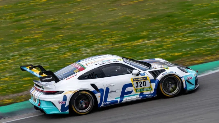 Coche de carreras blanco y azul rodando a alta velocidad en un circuito