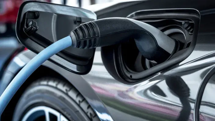 Detalle del cable conectado al punto de recarga de un coche eléctrico durante la carga