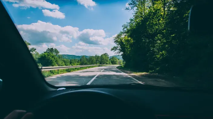Vista desde el interior de un coche en una carretera rural.
