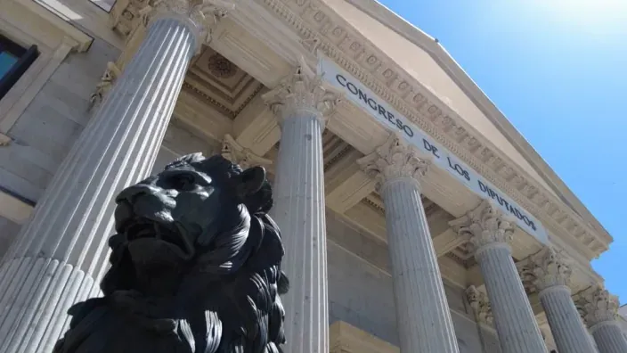 Fachada del Congreso de los Diputados en Madrid, con uno de sus leones en primer plano. Símbolo de la democracia y la política española.