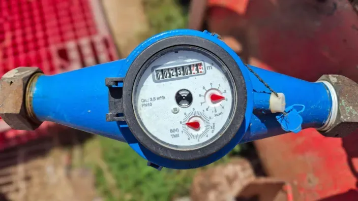 Contador de agua instalado en una tubería azul