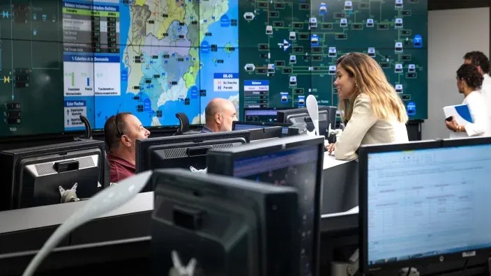 Sala de control de Enagás con pantallas y personal supervisando operaciones energéticas.