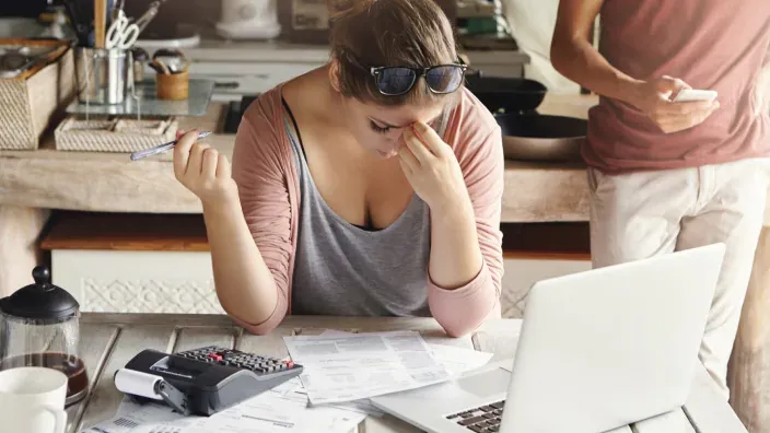 Mujer estresada gestionando sus finanzas personales.