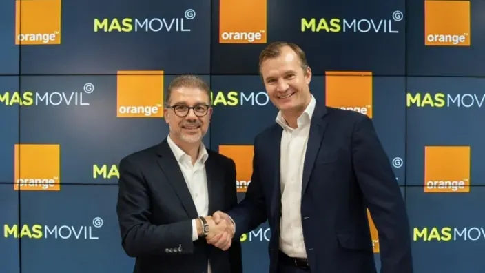 Ludovic Pech y Meinrad Spenger sellando la fusión de Orange y MásMóvil ante los logos de ambas marcas.