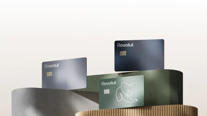 Tres tarjetas metálicas de Revolut en diferentes colores, representando las opciones de diseño premium.