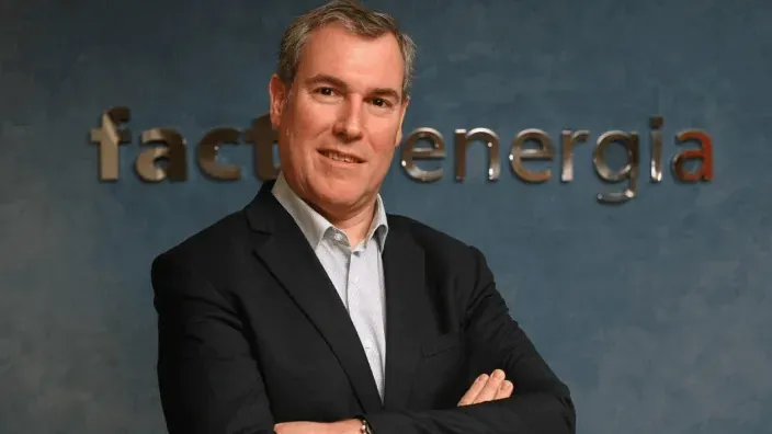 Retrato corporativo de Emilio Rousaud, CEO de Factor Energia, con el logotipo de la compañía al fondo