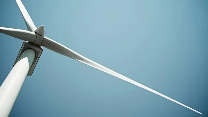 Aerogenerador de energía eólica renovable bajo un cielo azul despejado, representando la sostenibilidad.