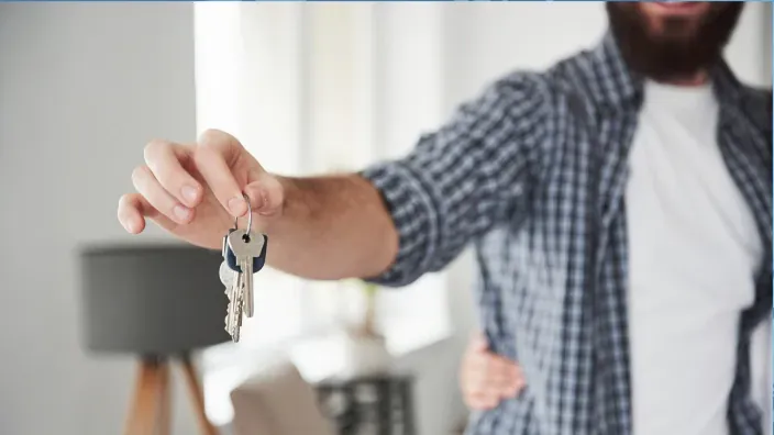 Joven mostrando las llaves de su nueva vivienda