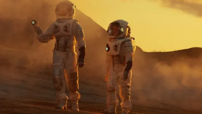 Dos astronautas explorando la superficie de un planeta desértico similar a Marte.