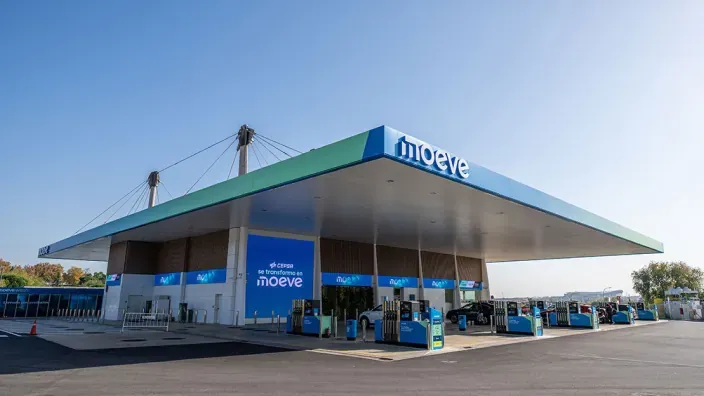 Estación de servicio Moeve con surtidores y marquesina corporativa en horario diurno.