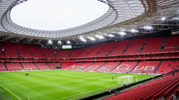 Vista interior del estadio San Mamés del Athletic Club de Bilbao con las gradas rojas y el terreno de juego