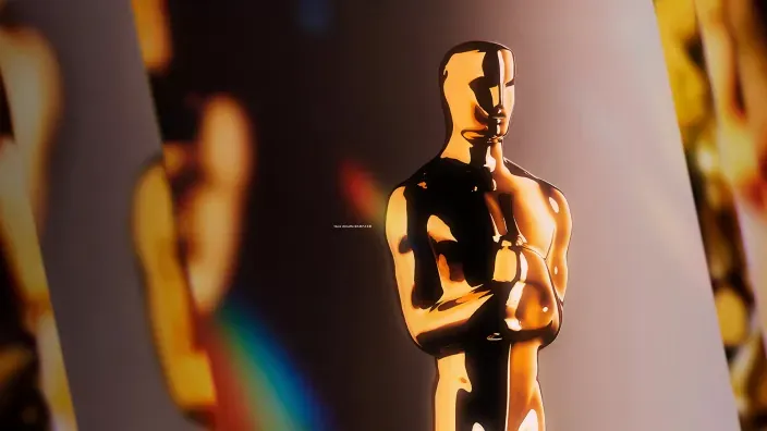 Primer plano de la estatuilla de los Premios Oscar iluminada en tonos dorados