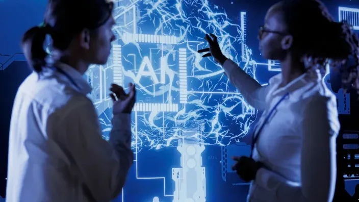 Expertos analizando un cerebro digital con inteligencia artificial en una pantalla futurista de color azul.