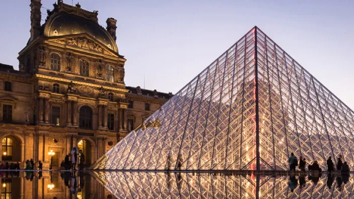 Pirámide y edificio del Museo del Louvre en Parísa última hora de la tarde.
