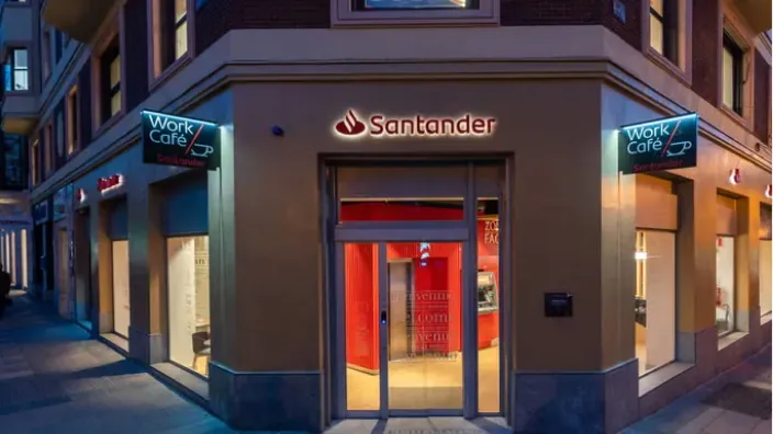 Fachada de un Work Café Santander en la esquina de una calle urbana al anochecer